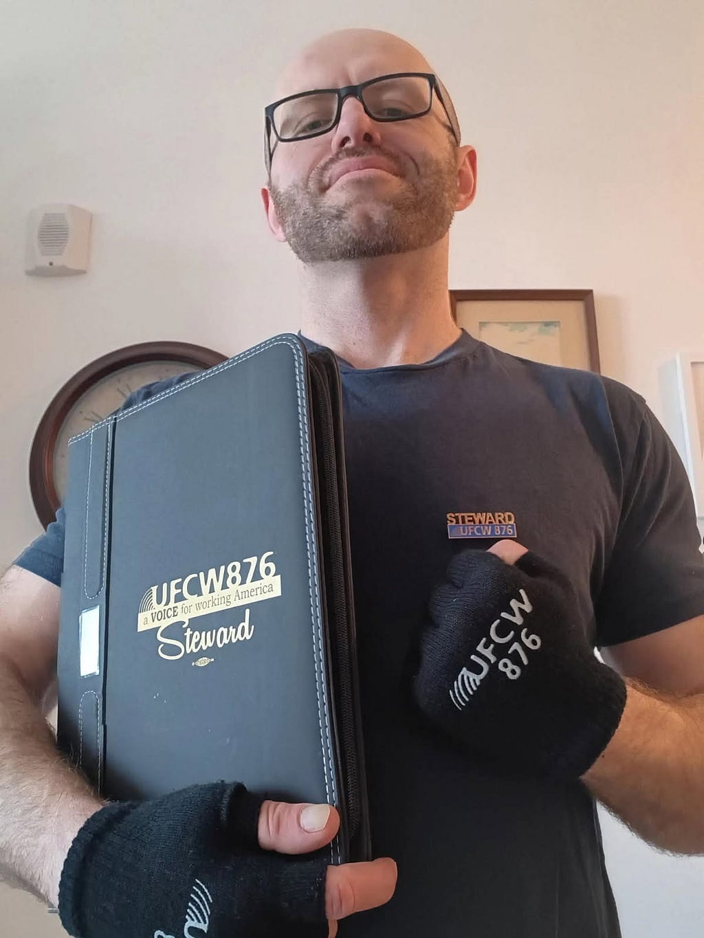 The author and local union steward, Rob Switzer, in United Food and Commercial Workers International Union (UFCW) gear including gloves, a branded t-shirt, and a binder.