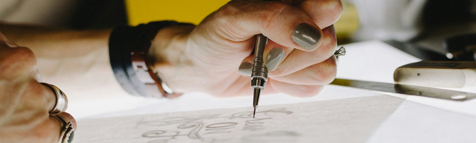 A woman is creating with pen and paper.