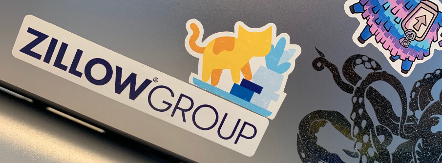 A sticker on a laptop of a cat pushing a vase off a table