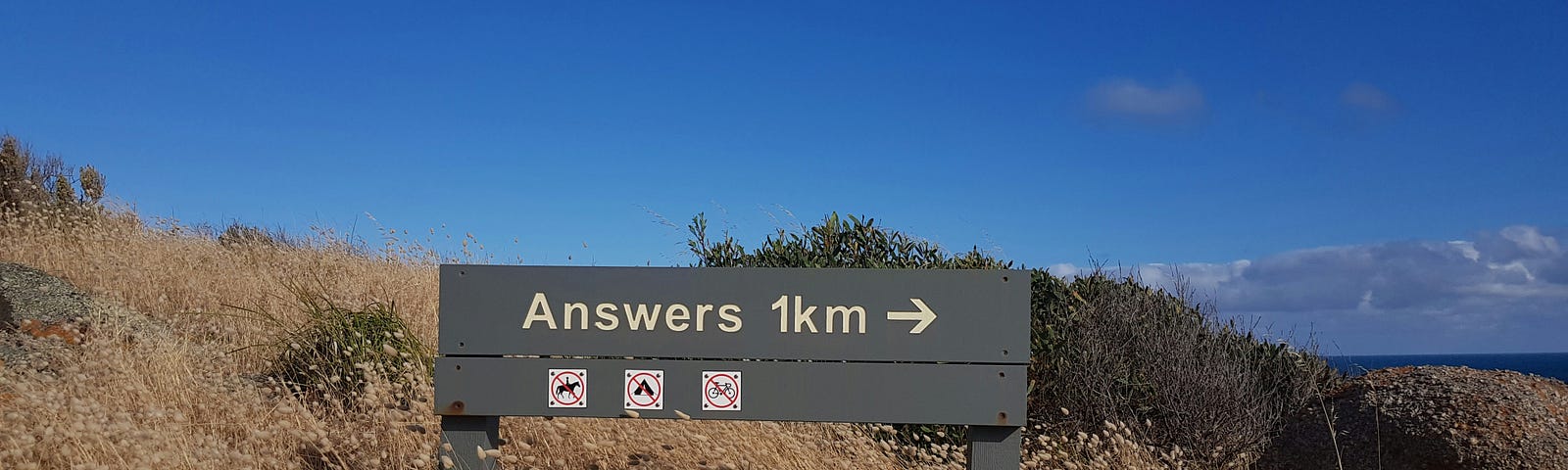Sign that says “Answers 1KM” with an arrow pointing right.
