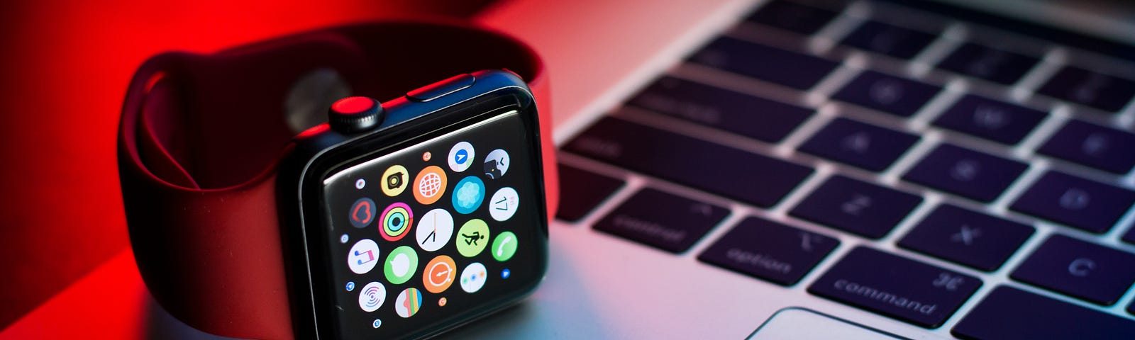 an apple watch sitting on a macbook keyboard