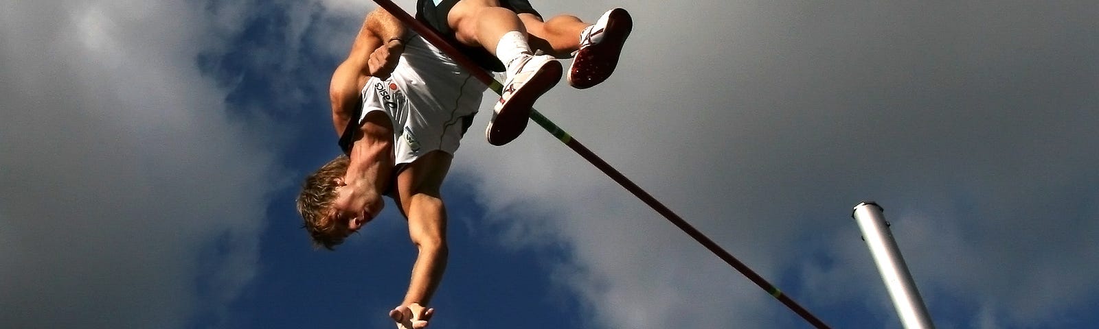 Male pole-vaulter clearing the bar