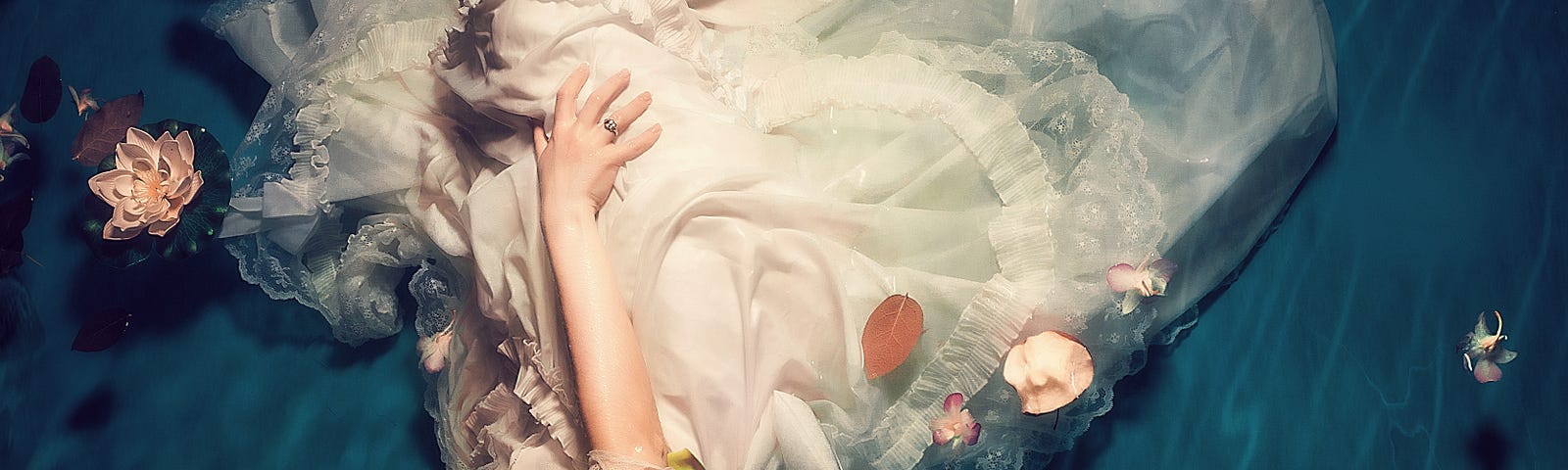 A woman in white dress under water, resting on the river bed, with intense emotions.