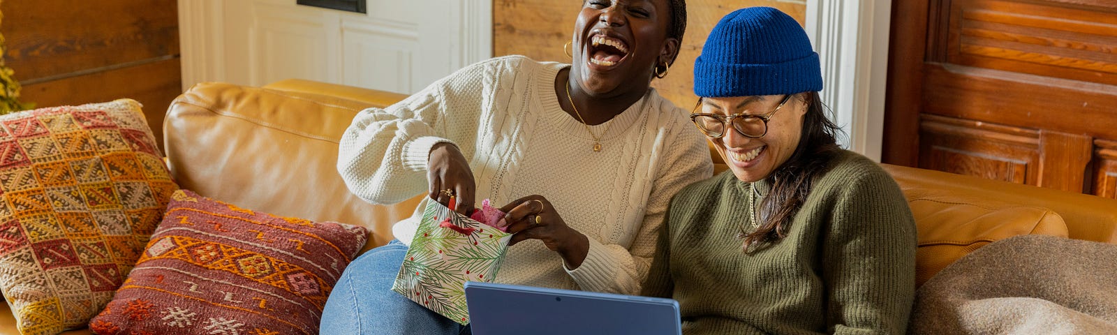 two people laughing over an open computer