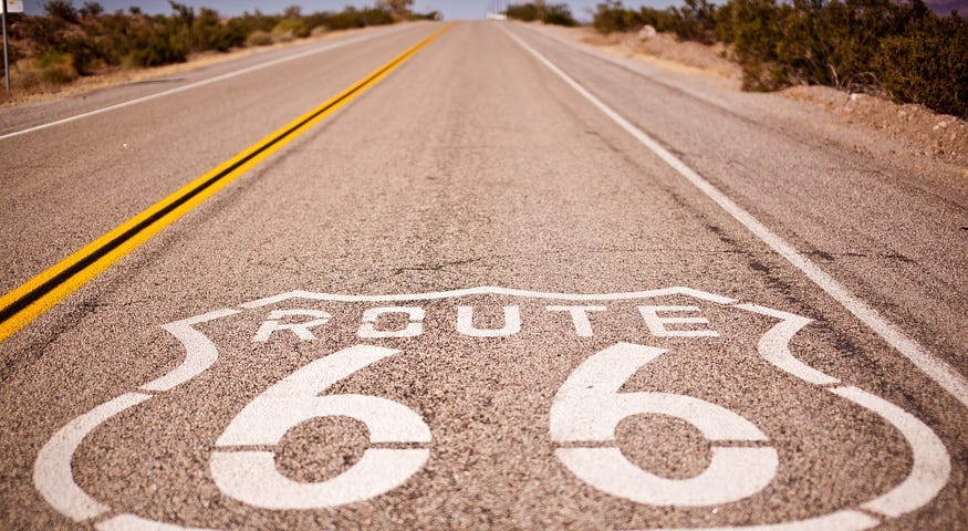 A long straight empty road with Route 66 written on it