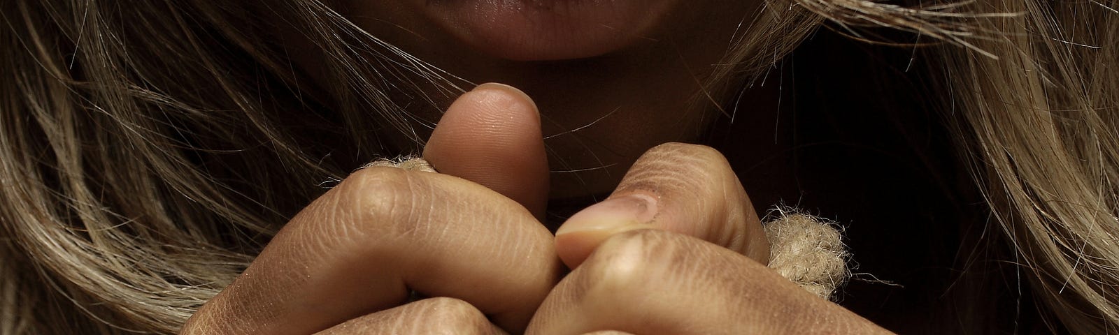 woman’s wrists tied together with rope