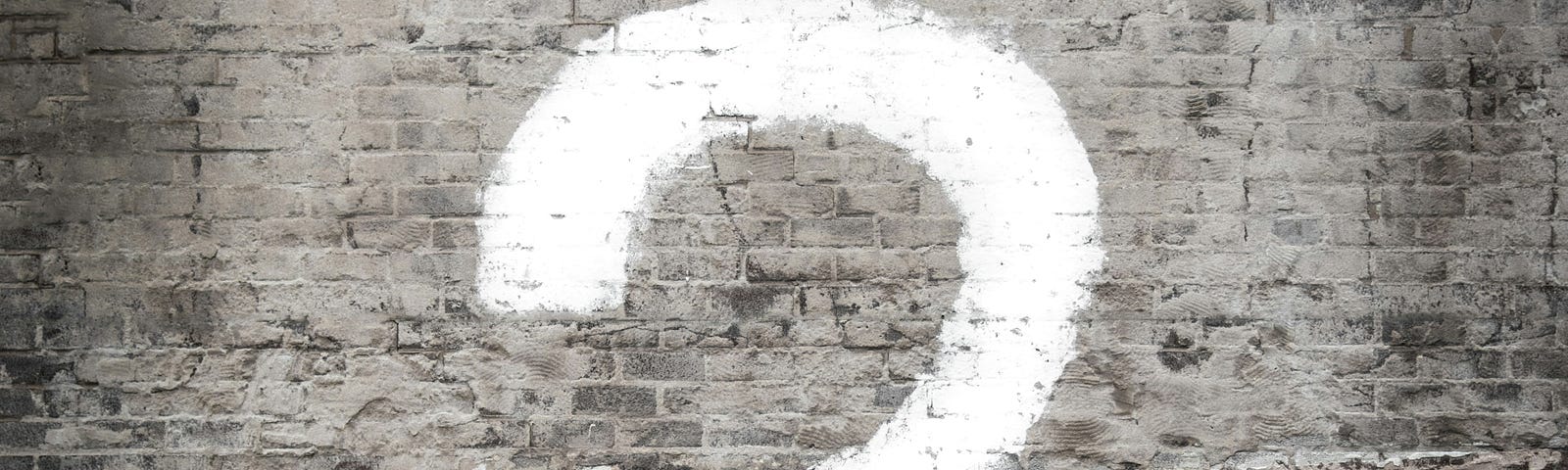 Question mark on brick wall.