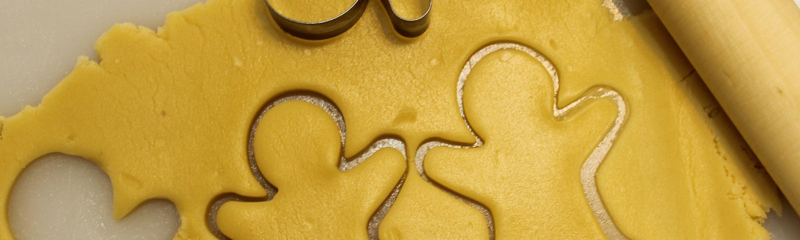 Gingerbread outlines in freshly rolled cookie dough