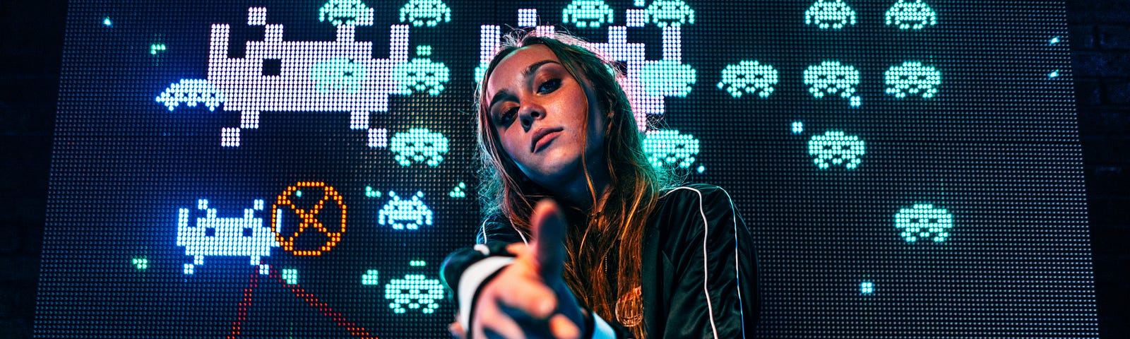 Woman pointing down at you with Space Invaders in the background