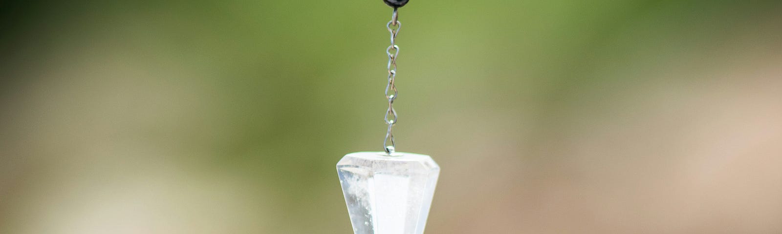 A crystal pendulum hanging from a chain.