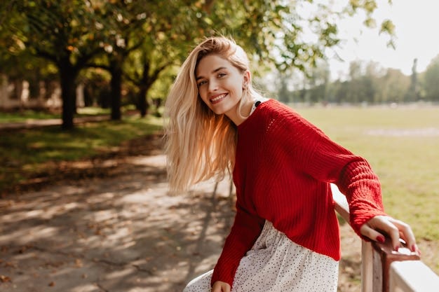 Cheerful young woman in bright sweater smiling at the camera