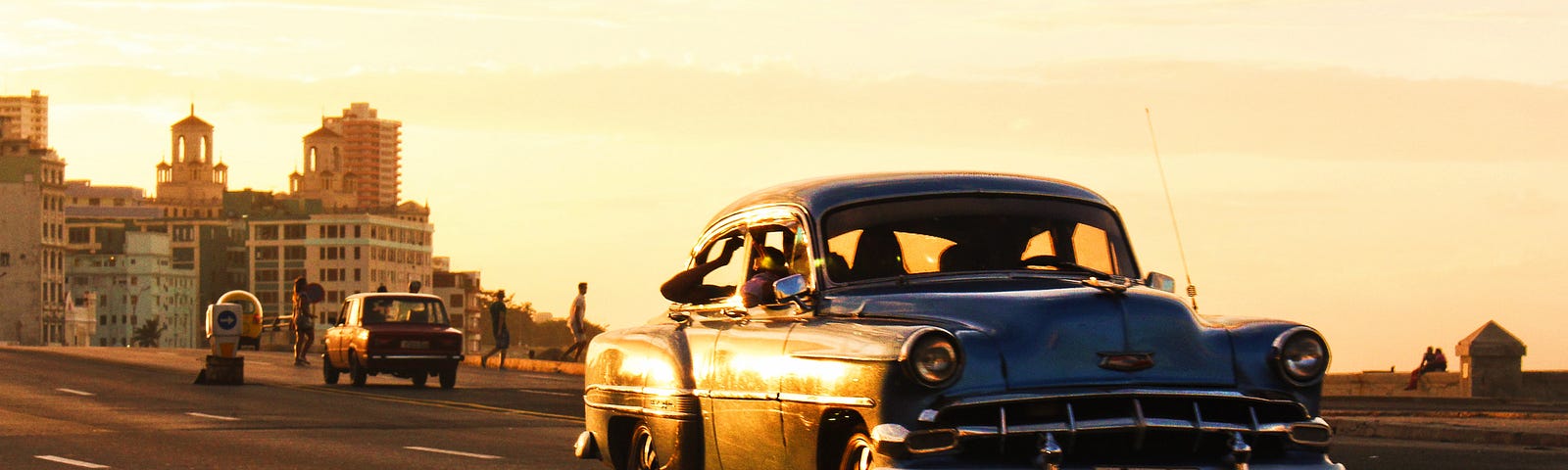 An old car driving at sunset in Cuba