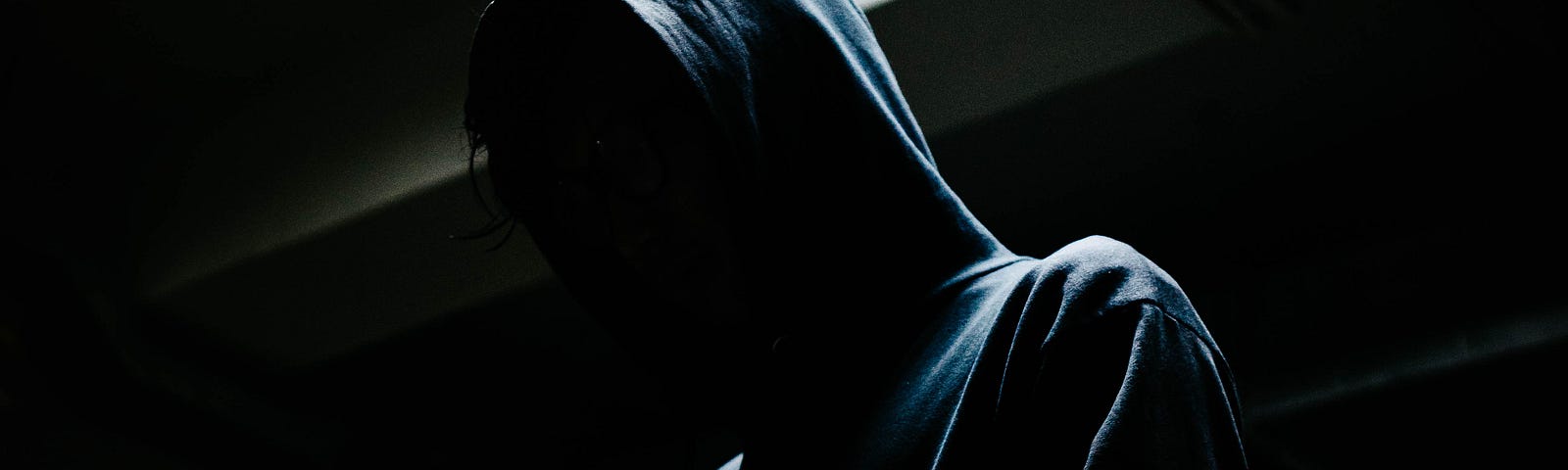 A hooded figure in the dark