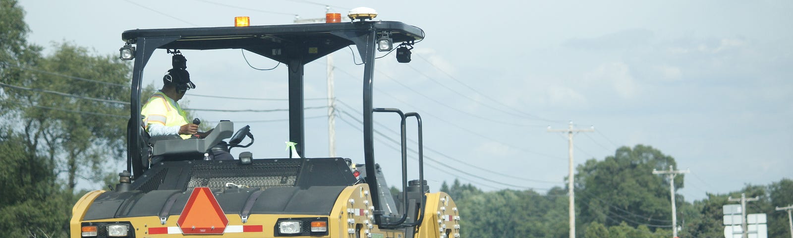 Yellow and black asphalt steamroller…apparently flattening the earth.