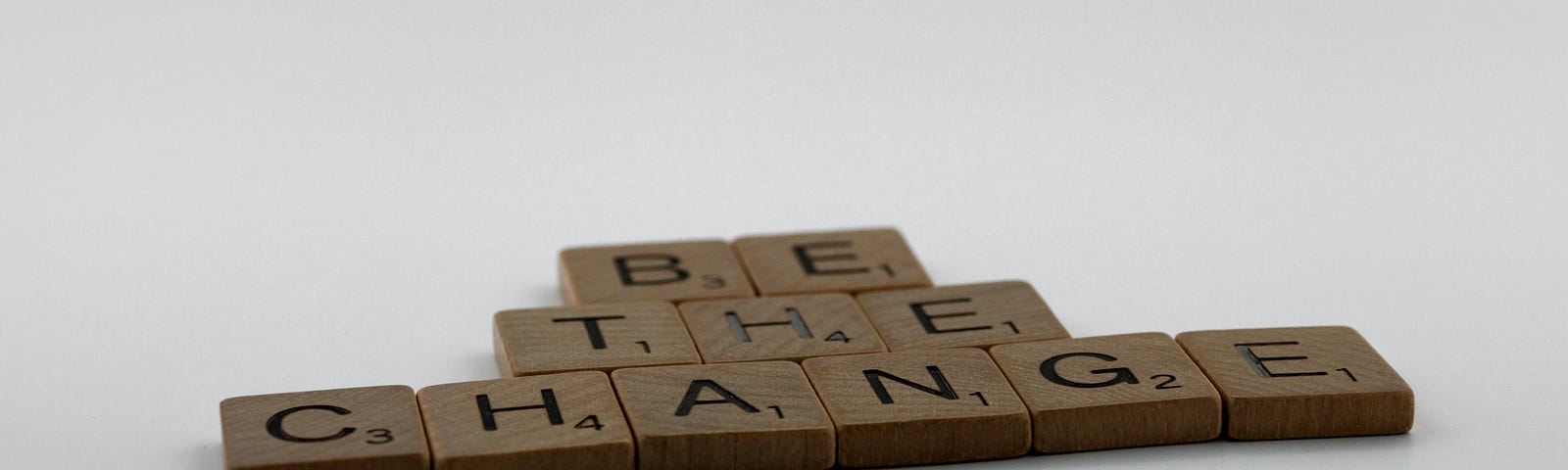 Scrabble tiles spell out “Be the Change.”