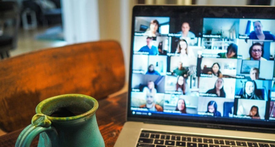 A laptop on a table and a coffee mug on the side