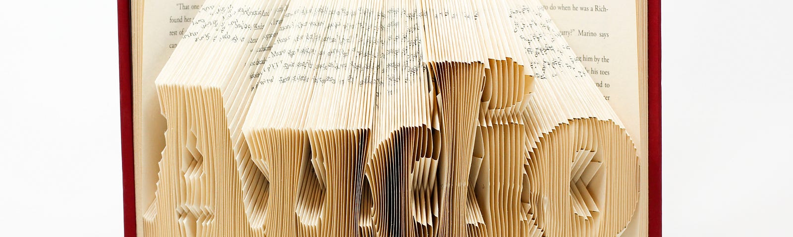 The inside of a novel cut like an accordion in letters that reads “Audio”.