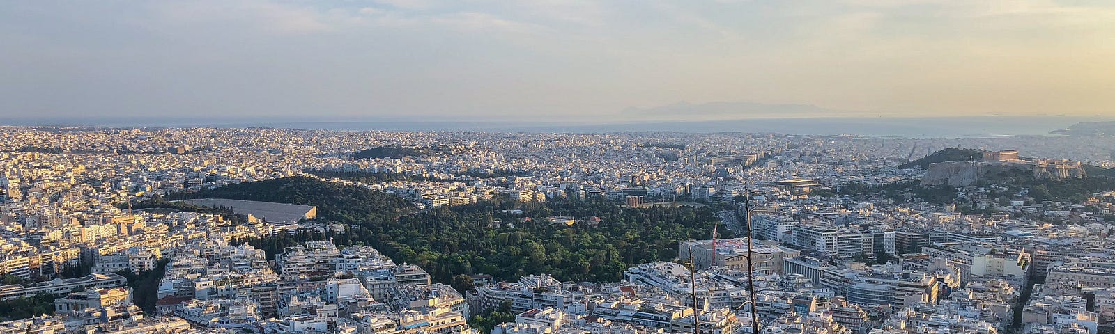 Woman with arms outstretched, her back to the camera, feeling free, overlooking a city.