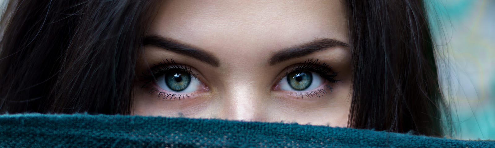 Woman peering over turquoise cloth