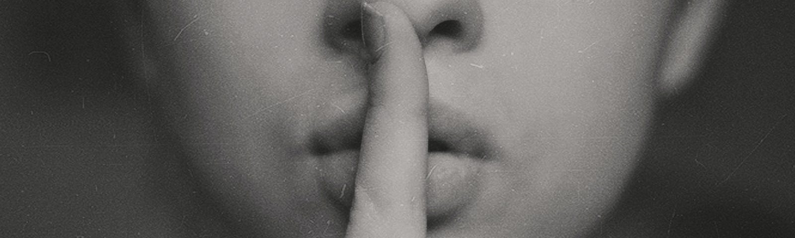 black and white photograph of a woman with her finger over her mouth