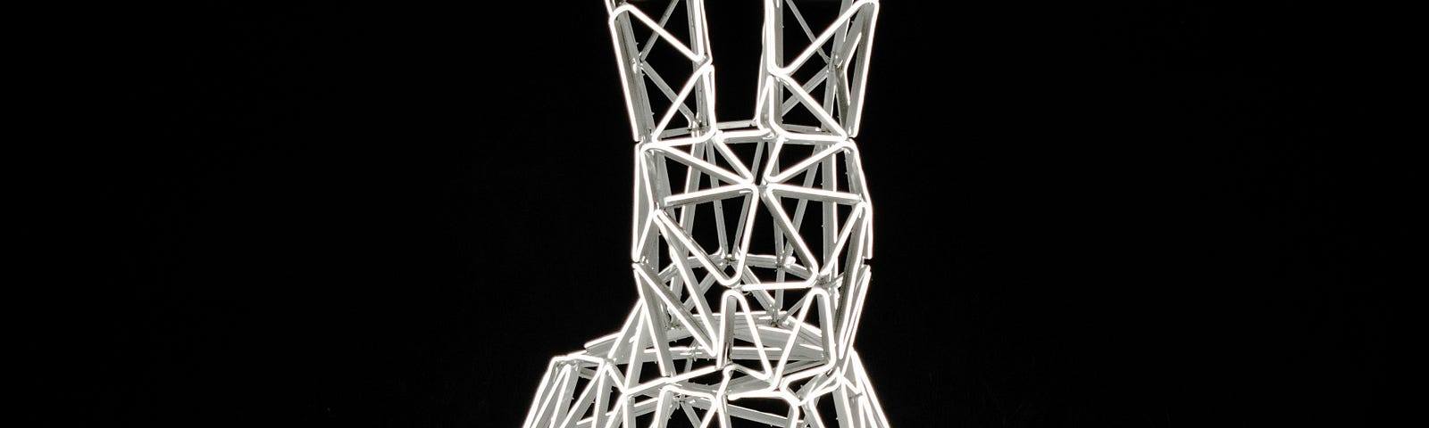 Grid-like sculpture of a white rabbit shining in a dark place.