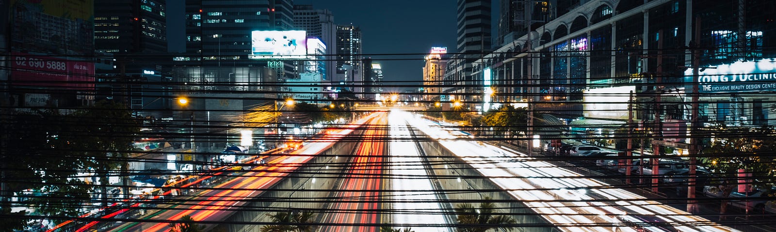 A city picture where the traffic is blurred into streaks of light due to speed.
