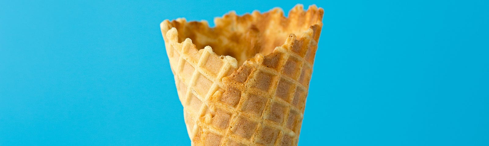 Image of an empty ice cream cone on a blue background.