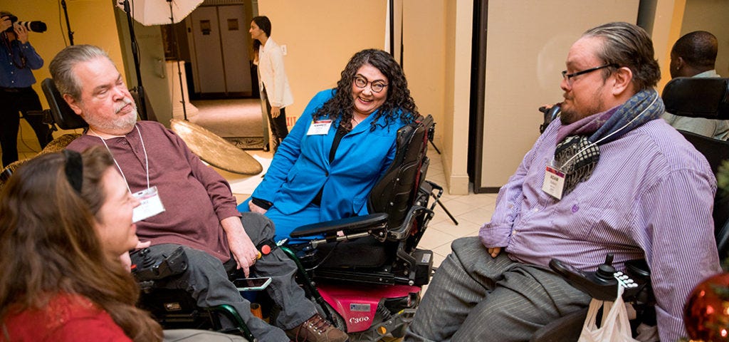 Rahnee Patrick and three other people sit in a circle having a casual conversation.