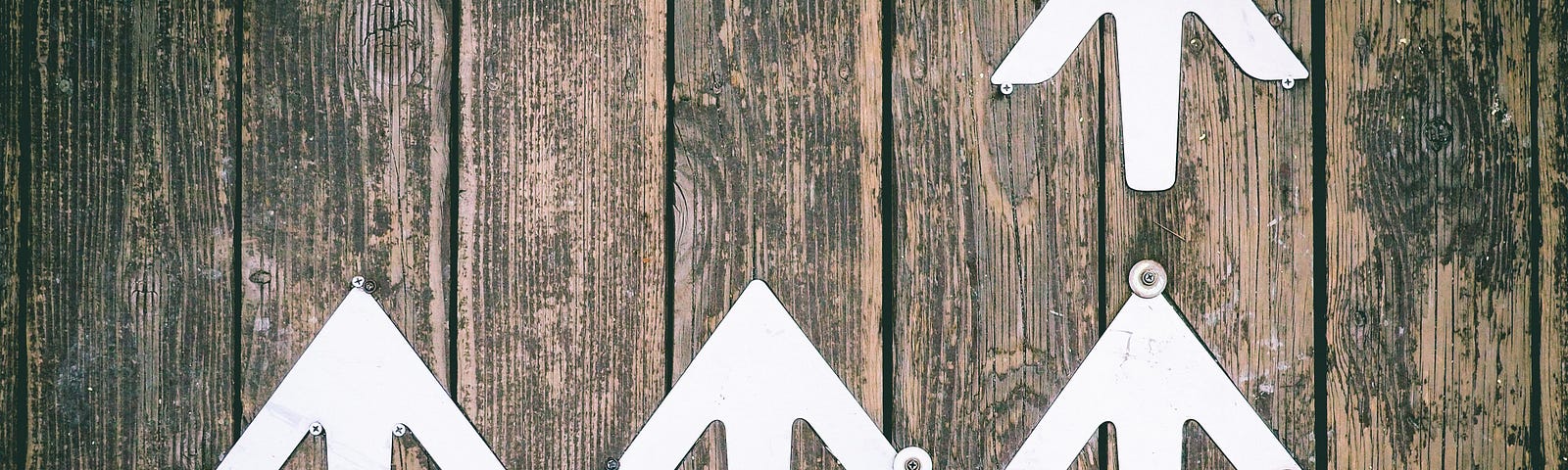 White arrows painted on a boardwalk