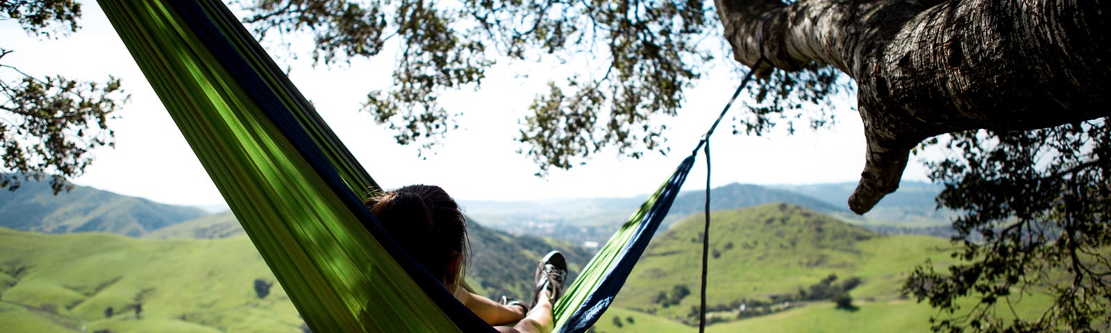 this is a photo of a child on a hammock looking at a hillside