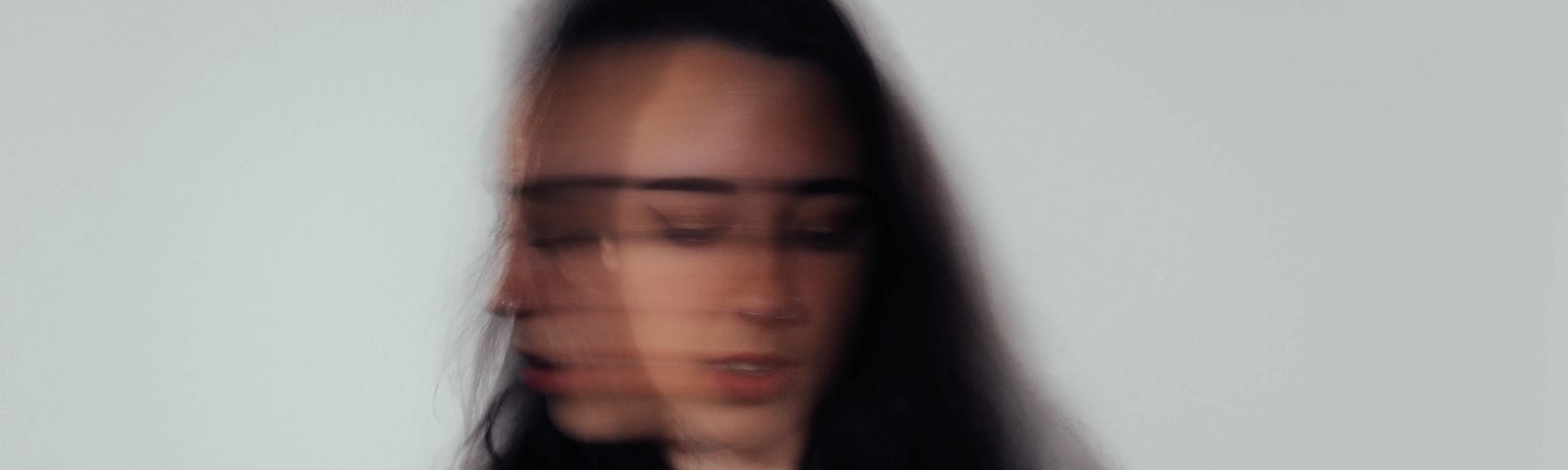 A woman experiencing social anxiety — blurring her face to depict the confusion she feels on the inside.