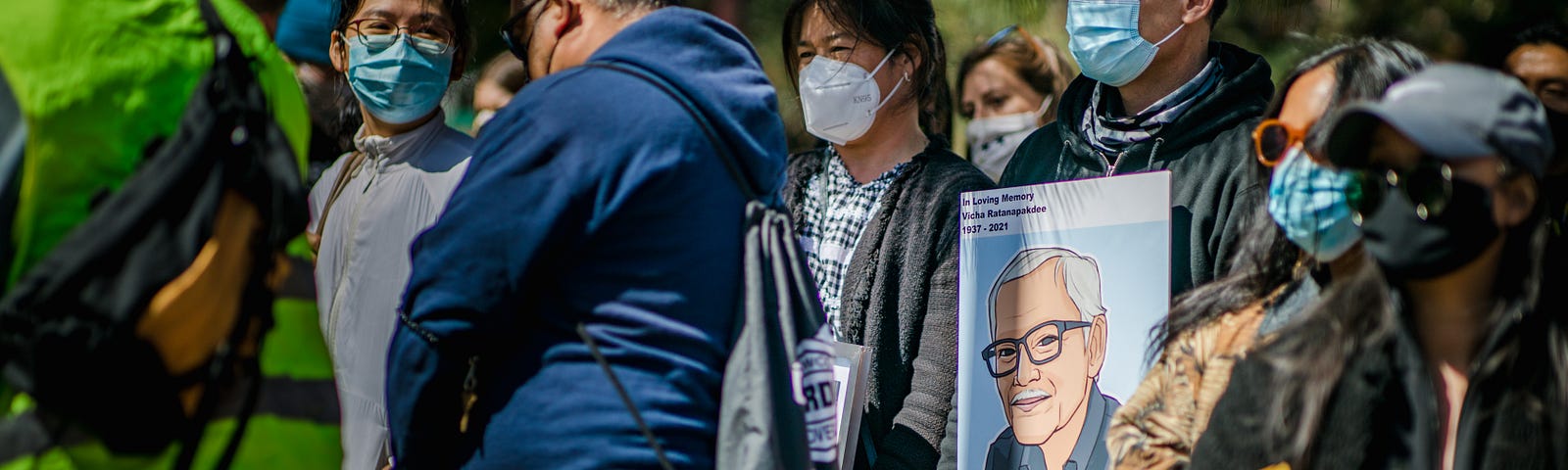 Masked protesters carry an image of Vichar Ratanapakdee, a Thai immigrant killed in an unprovoked attack by a 19-year-old man in San Francisco on January 28, 2021