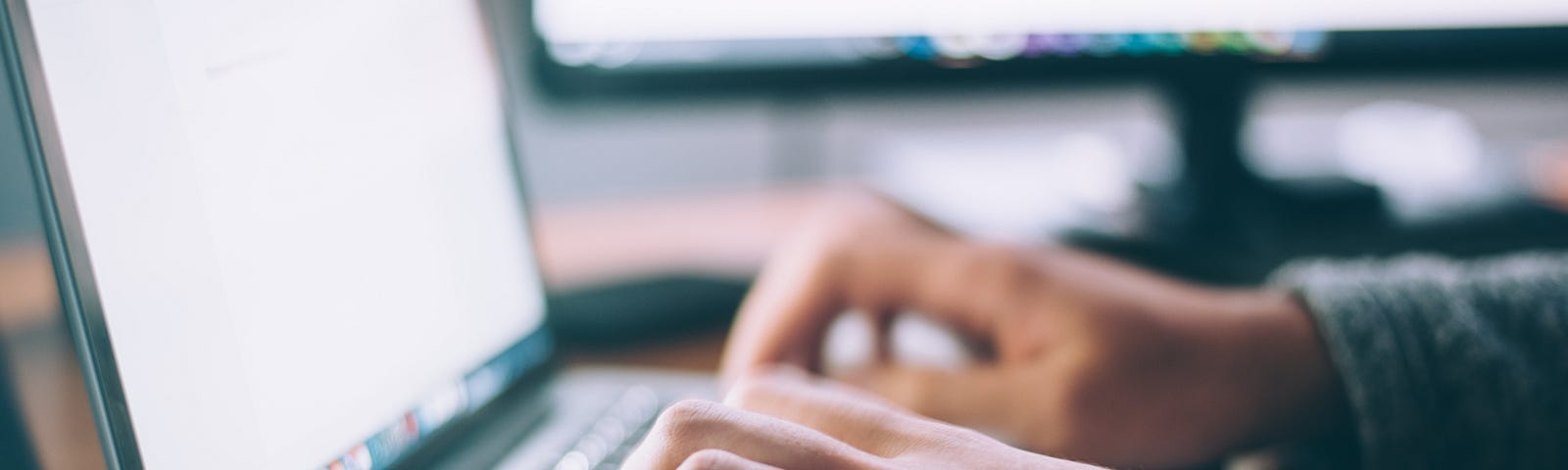 Hands typing on laptop keyboard