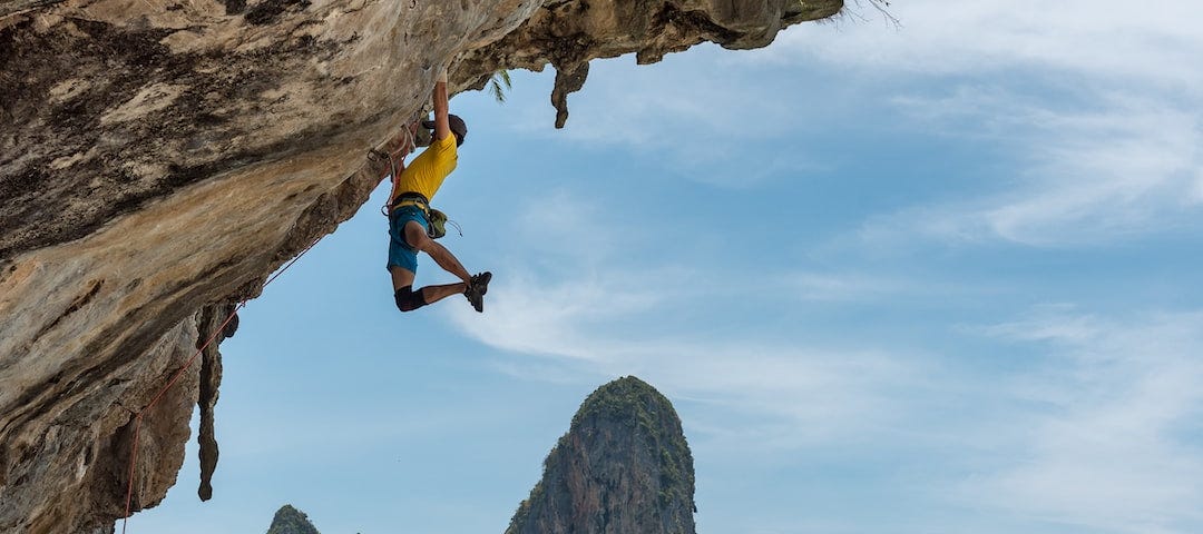 A rock climber hangs from a cliff.