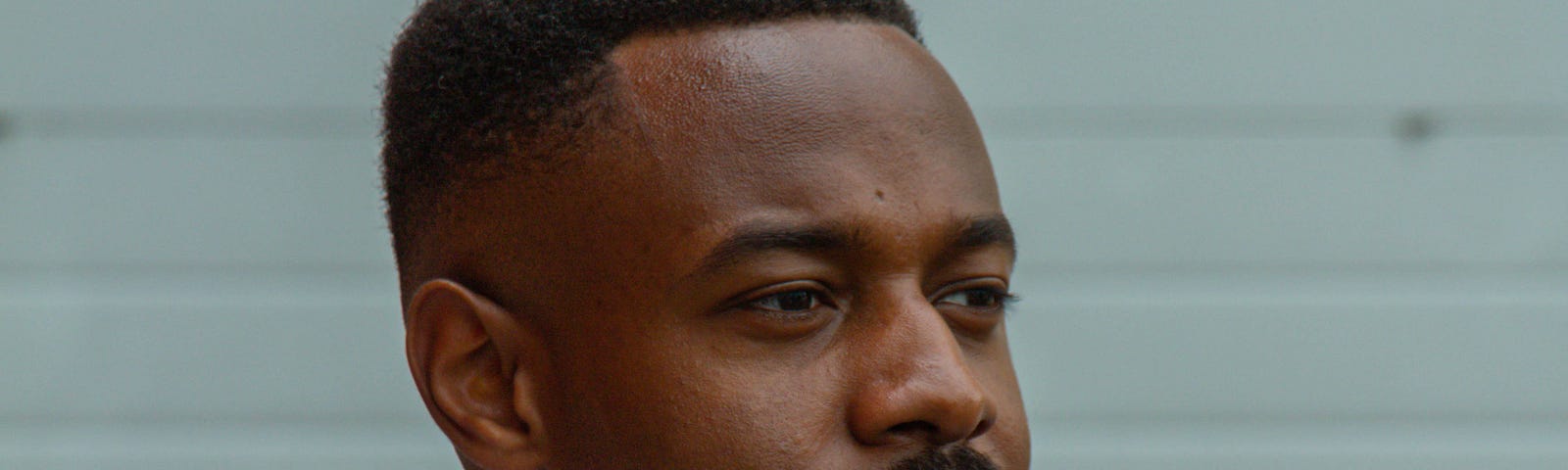 Man in blue shirt glancing to side of camera.