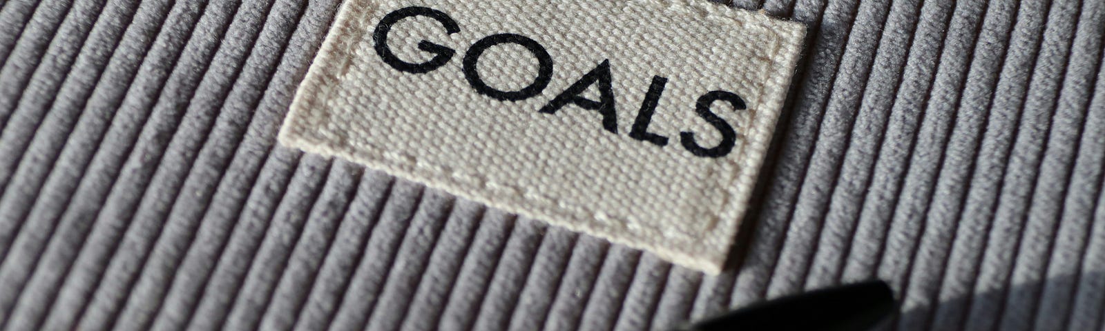 An image of a clothing tag that says goals