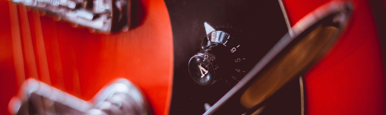 This shows a close up of a red guitar.