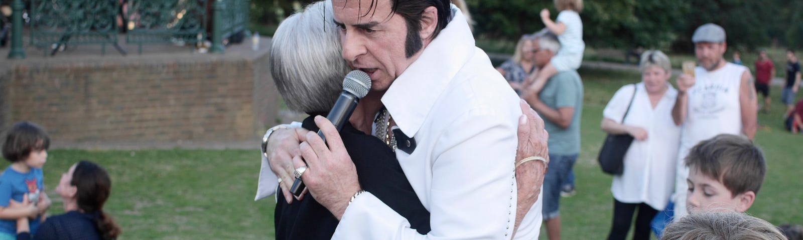 A Photo of an Elvis Impersonator Hugging a Woman by Viktoria Blomberg Book on Unsplash