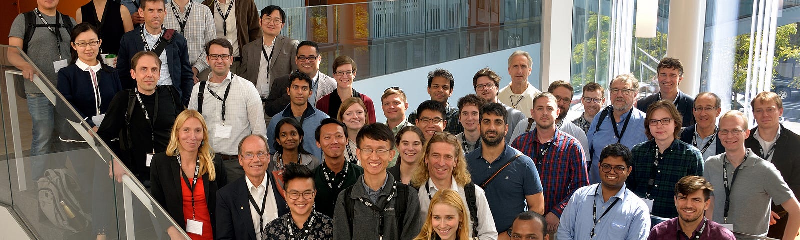 A large contingent of quantum scientists pose for a group photo on the stairs of the Singh Center for Nanotechnology