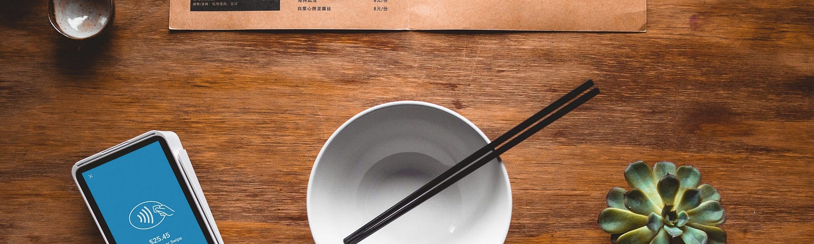 Chopsticks in a bowl plus a menu