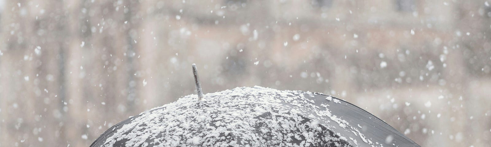 Picture of a person under an umbrella in heavy snow via Alt text on Medium