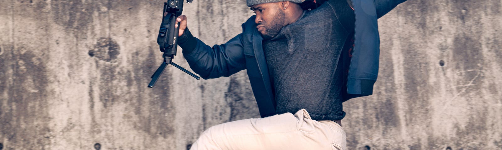 A man in midair while holding his camera.