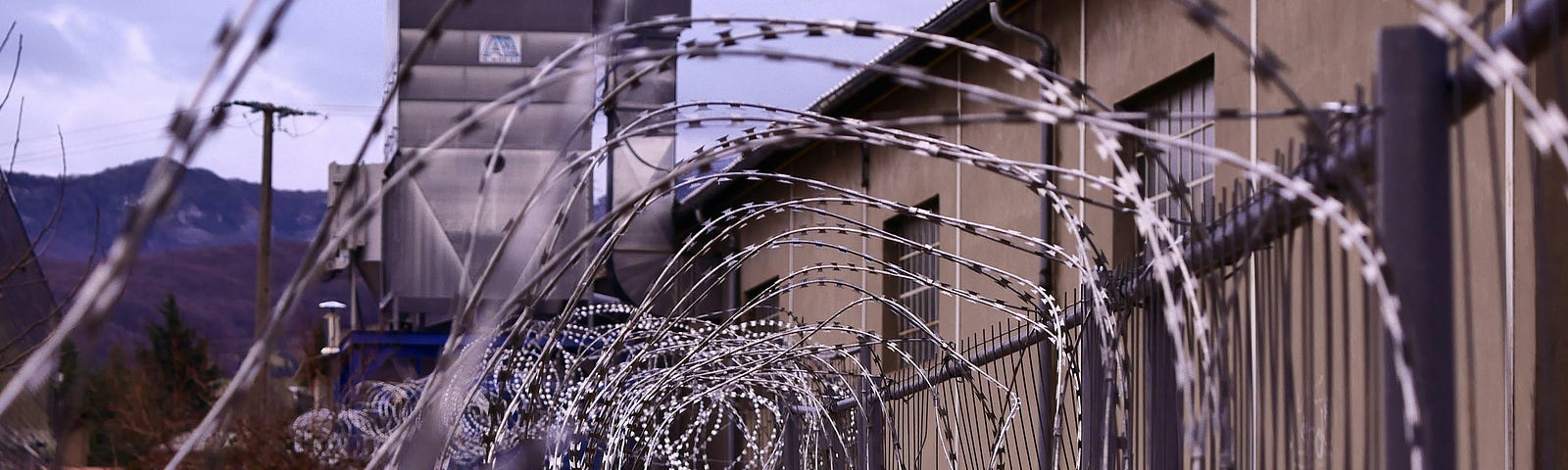 Barbed wire in a spiral/tunnel shape outside a prison’s walls