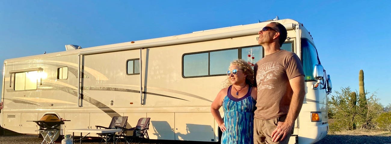 A couple standing in front of an RV.