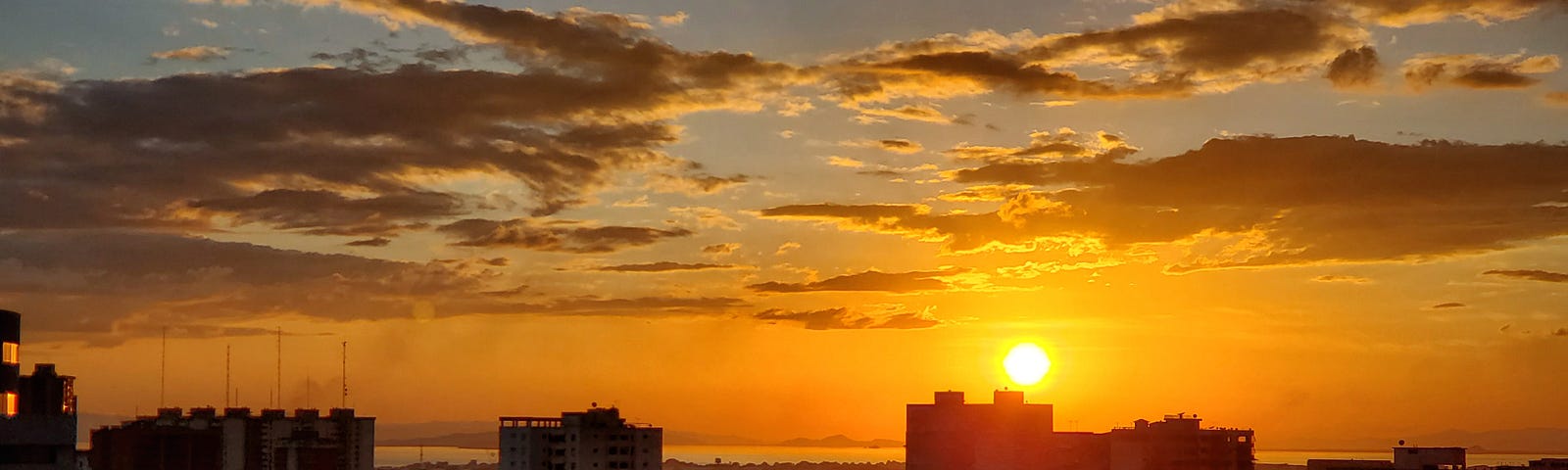 A golden sunset over several skyscrapers.