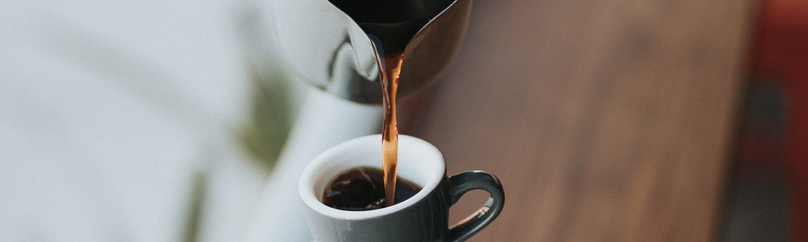 We see a hand pouring coffee into a small cup on top of half a dozen haphazardly placed nested cups. When it occurs, coffee withdrawal typically begins 12 to 24 hours after caffeine cessation.