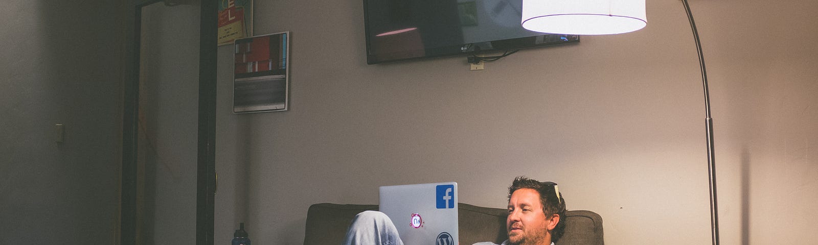 A man is working from home on a couch