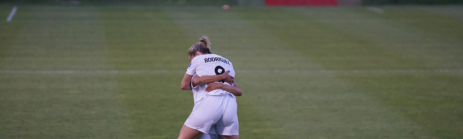 Two soccor players celebrating victory with a dramatic hug.