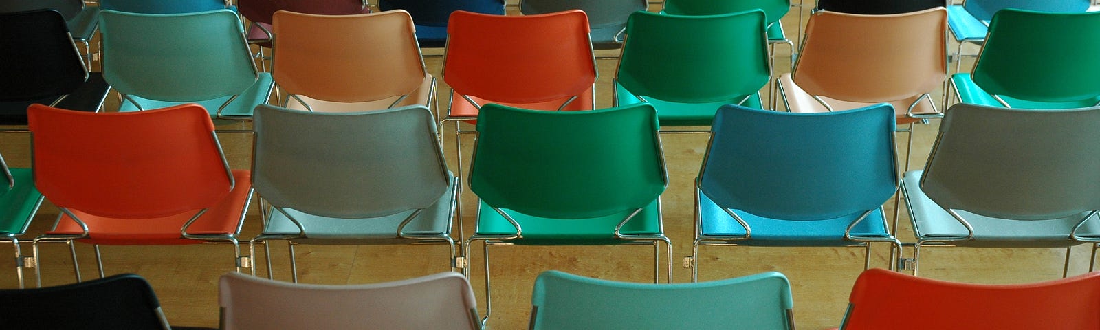 Many empty, multi-colored chairs in rows