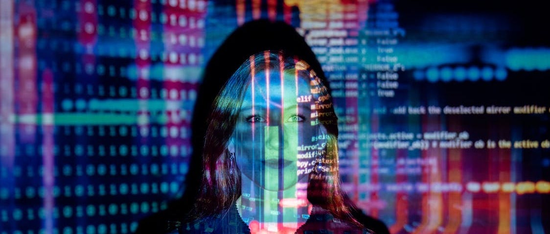 A woman stood in front of a projection of code and numbers